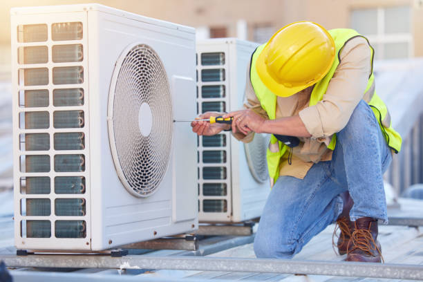 HVAC technician inspecting an outdoor air conditioning condenser unit